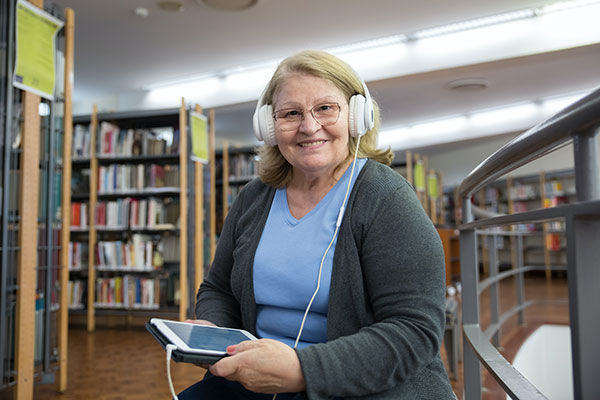 woman in library with electronic device