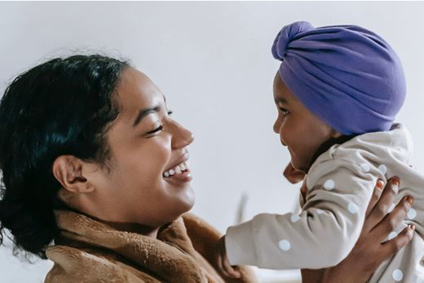 cheerful black mother holding a baby and smiling