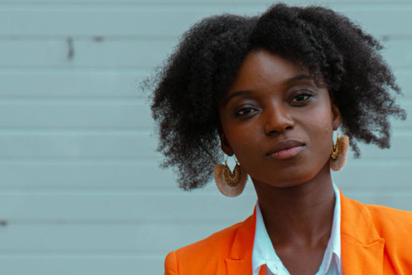 young woman standing near brick wall