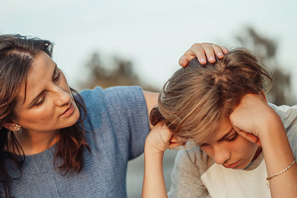 Mother comforting son with his head down