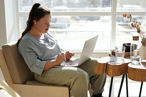 girl sitting on couch using laptop