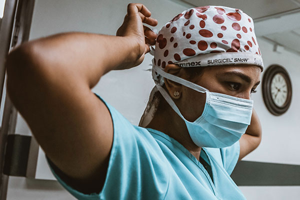 health care provider putting on their scrub hat