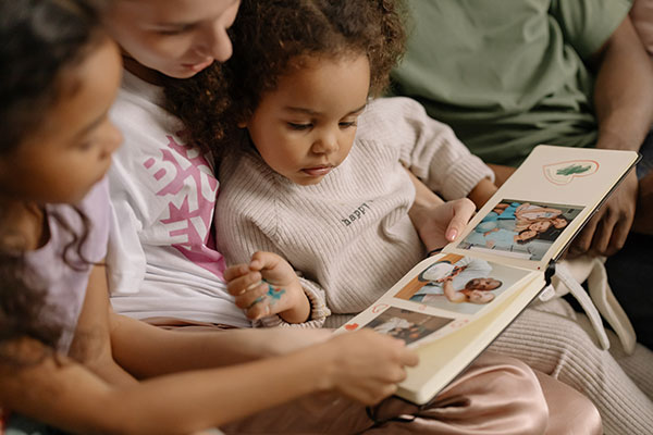 Mother with daughters looking at photo album