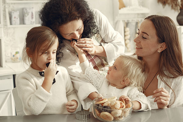 Several generations of women eating cookies